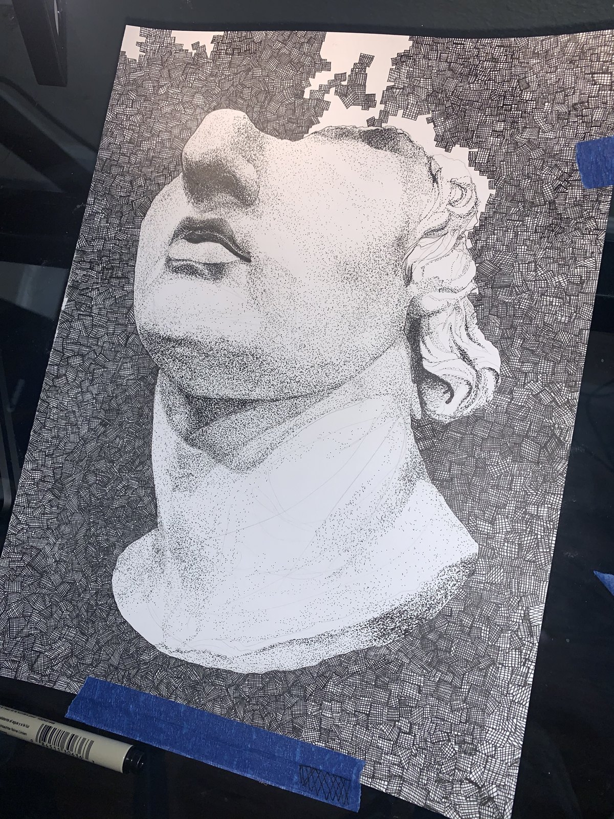 The classical bust in progress — stippling underway, taped to the desk