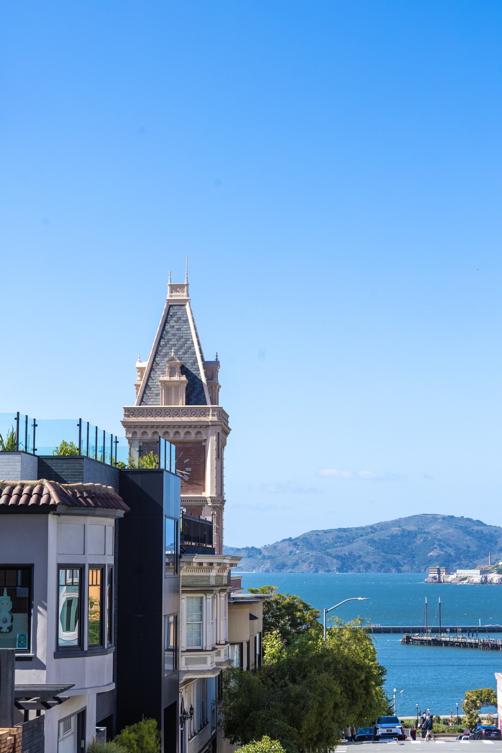 Victorian tower rising above rooftops, the bay behind
