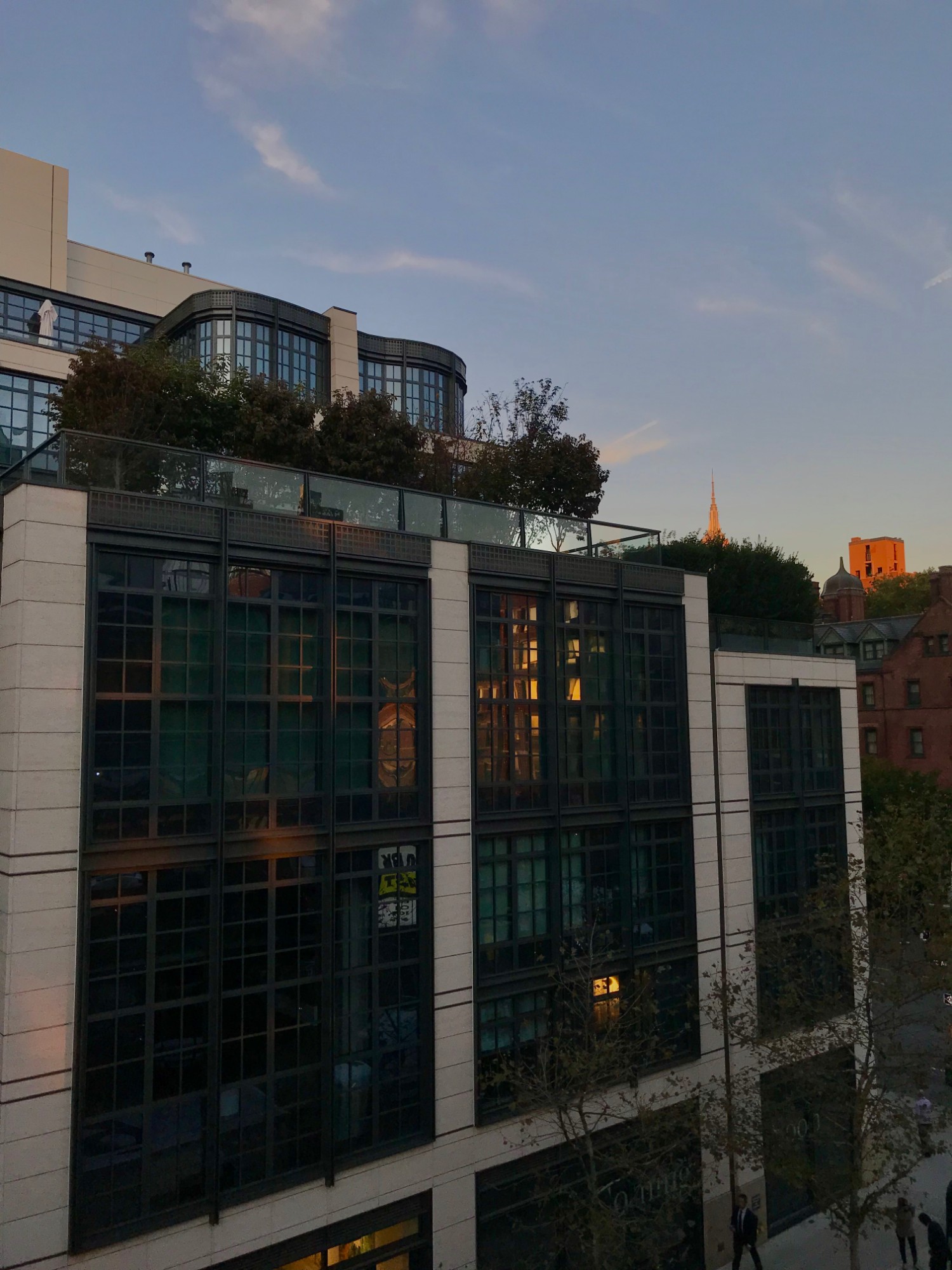 A downtown facade catching gold at sunset, a distant spire beyond