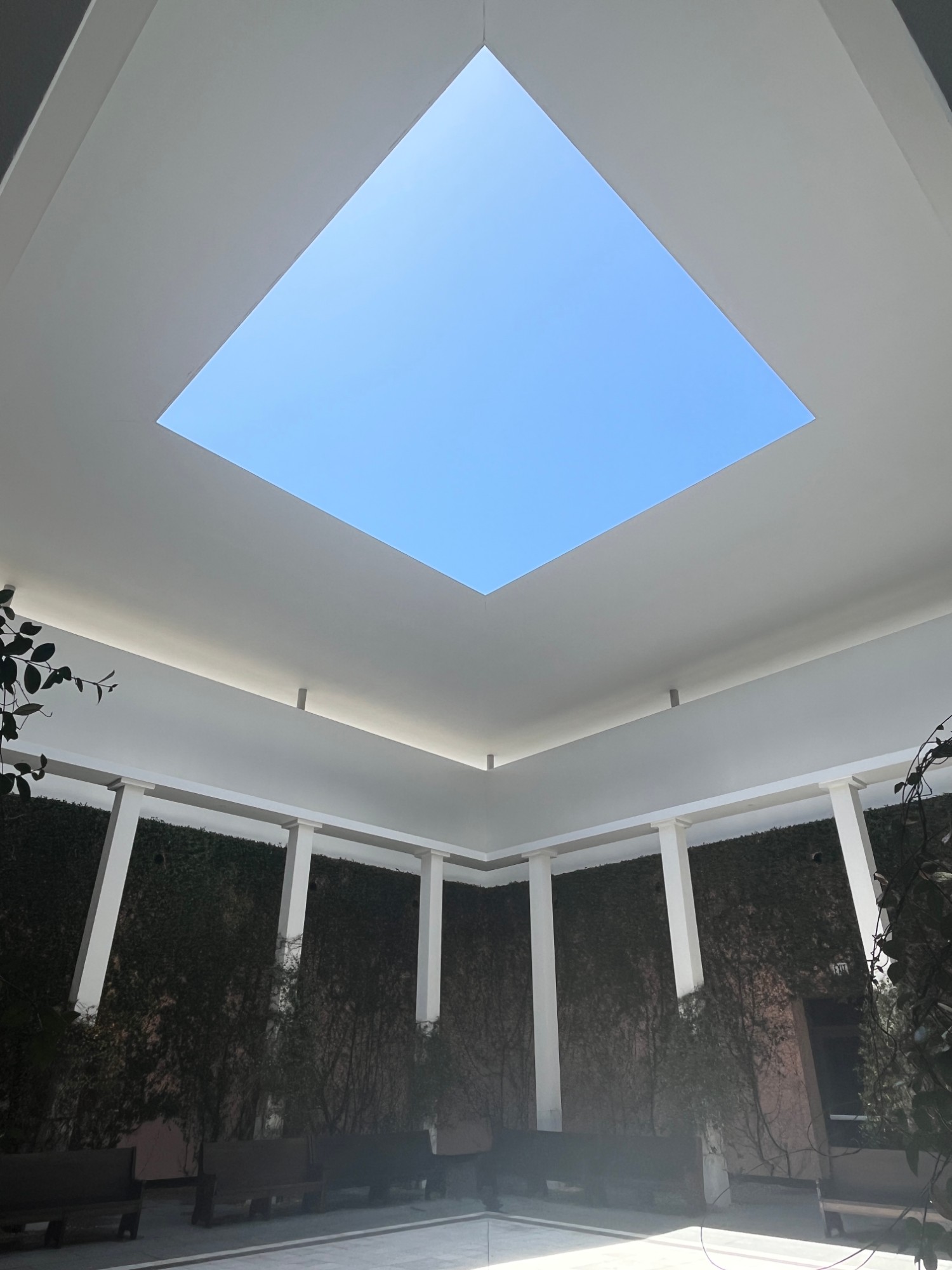 A square of blue sky through the open roof of a quiet pavilion